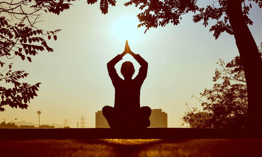 a woman meditation in nature during sunset