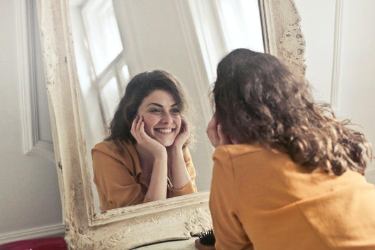 a woman smiles at the mirror